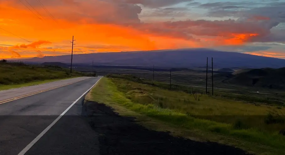 Saddle Road at sunset with Mauna Kea and Mauna Loa rising above the central Big Island