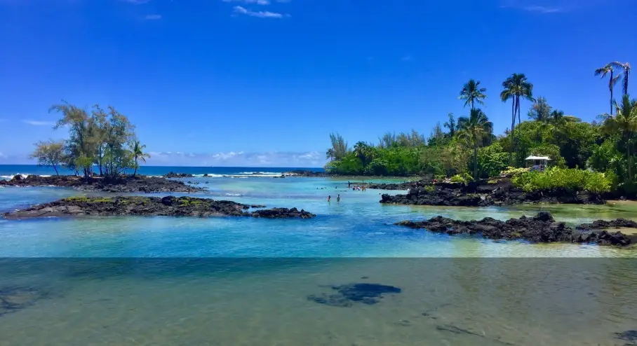 Carlsmith Beach Park lagoons on the Big Island, featuring protected lava rock tide pools, clear blue water, and tropical shoreline.