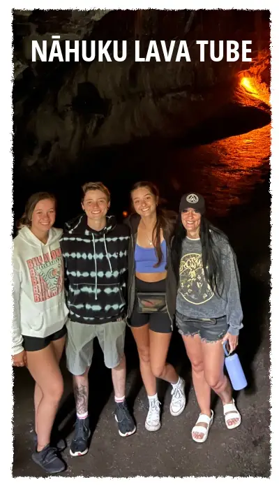 Guests exploring Nāhuku (Thurston) Lava Tube in Hawaiʻi Volcanoes National Park, standing inside a naturally formed lava tunnel lit by warm volcanic light.E