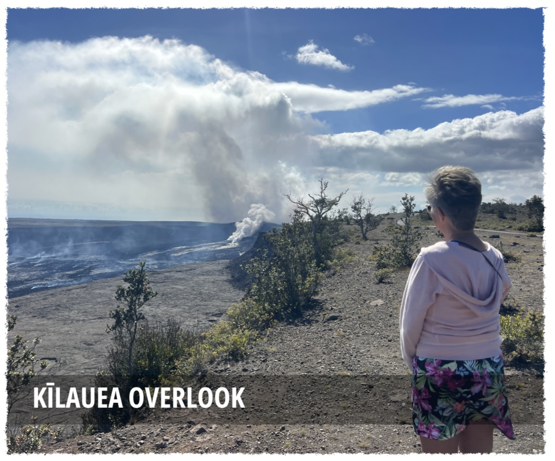 Visitor standing at a Kīlauea overlook watching volcanic steam rise from the crater in Hawaiʻi Volcanoes National Park
